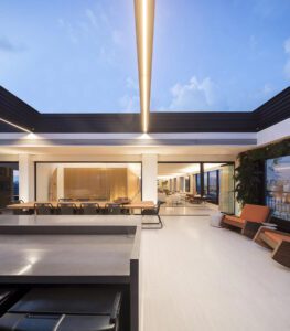 Vista ampla do espaço gourmet e living integrados no projeto Tavarua, apartamento duplex premiado com o Americas Property Awards 2017-2018, destacando a funcionalidade, o uso de materiais nobres e a assinatura de Fernanda Marques Arquitetura.