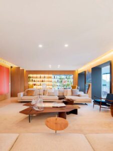 Sala de estar de luxo do premiado apartamento residencial Vista, projeto de Fernanda Marques vencedor do Design Award 2023, com mobiliário contemporâneo, marcenaria em madeira e iluminação embutida.